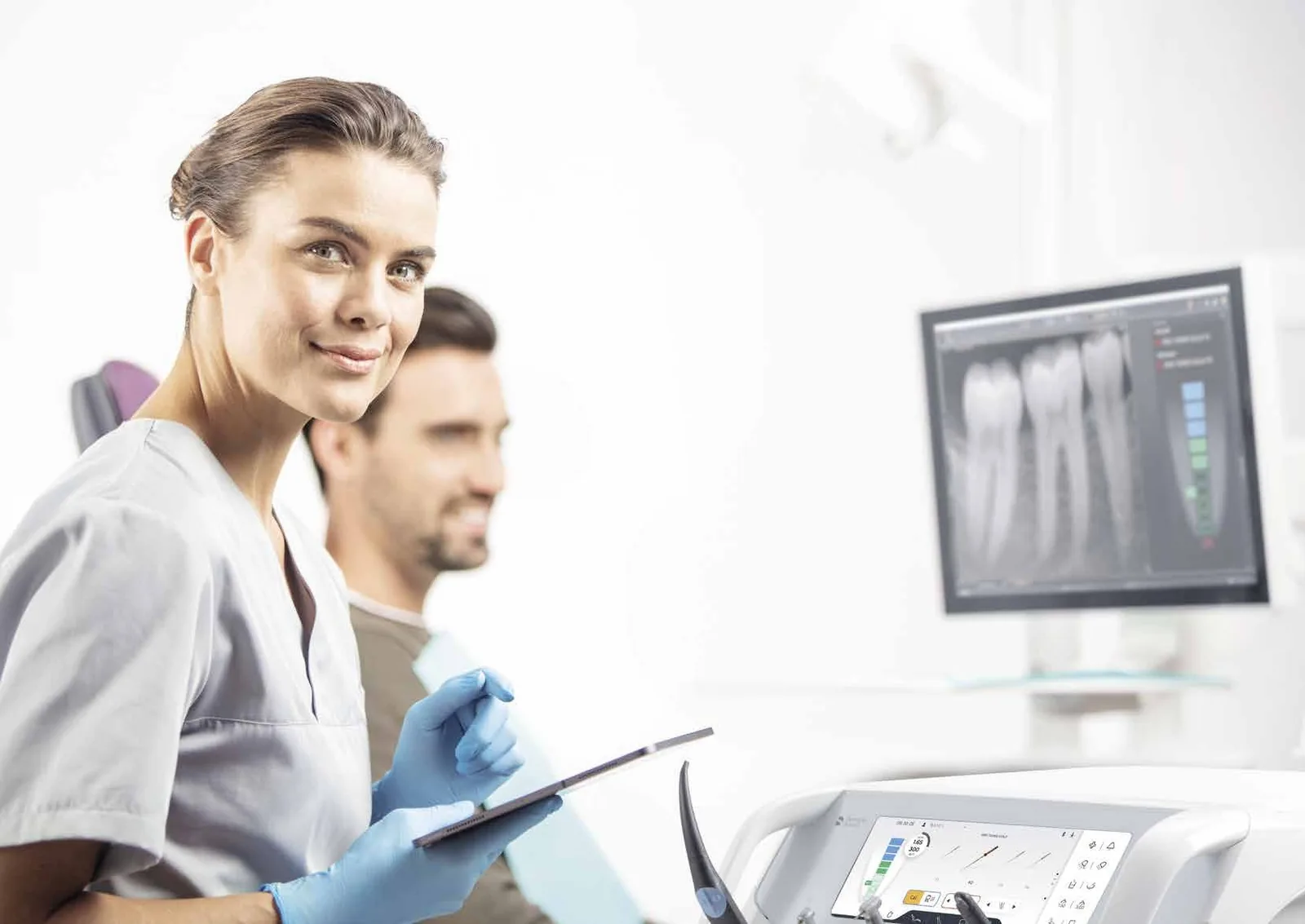 Odontólogo y auxiliar tratando a un paciente en una unidad Dentsply Sirona Axano